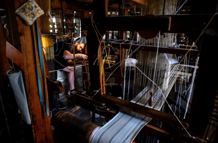 Un artisan travaille sur un métier à soie à la manufacture Prelle à Lyon, le 16 septembre 2019