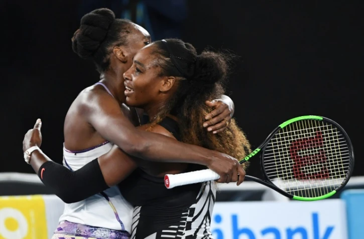 L'Américaine Serena Williams enlace sa soeur Venus après avoir remporté la finale de l'Open d'Australie, le 28 janvier 2018 à Melbourne