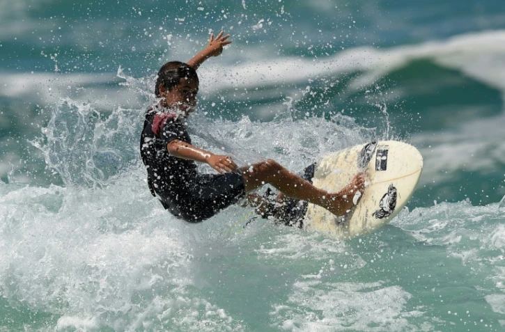 Rickson Falcao, 10 ans, surfe sur une vague au large de Saquarema, dans l'Etat de Rio, au Brésil, le 29 novembre 2017