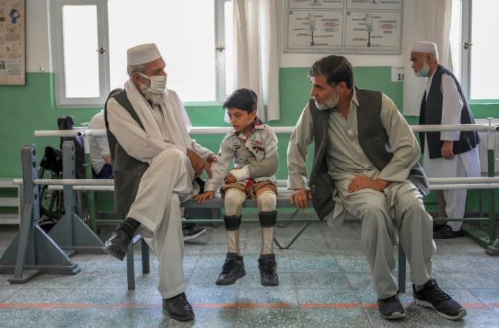 Un enfant amputé des deux jambes après avoir reçu des nouvelles prothèses au Centre de réhabilitation du Comité international de la Croix Rouge (CICR) à Kaboul le 11 octobre 2021
