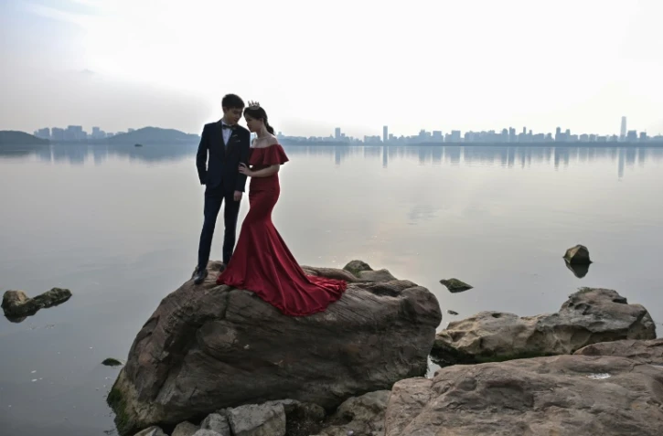 Un couple pose pour une photo de mariage, près d'un lac à Wuhan, dans la province du Hubei, en Chine, le 19 avril 2020