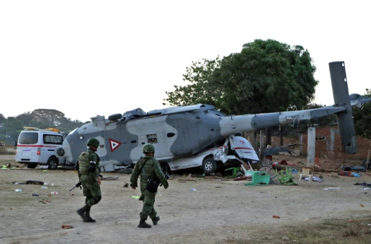 Des soldats de l'armée mexicaine marchent devant l'hélicoptère militaire et la camionnette à Santiago Jamiltepec, État d'Oaxaca, au Mexique, le 17 février 2018