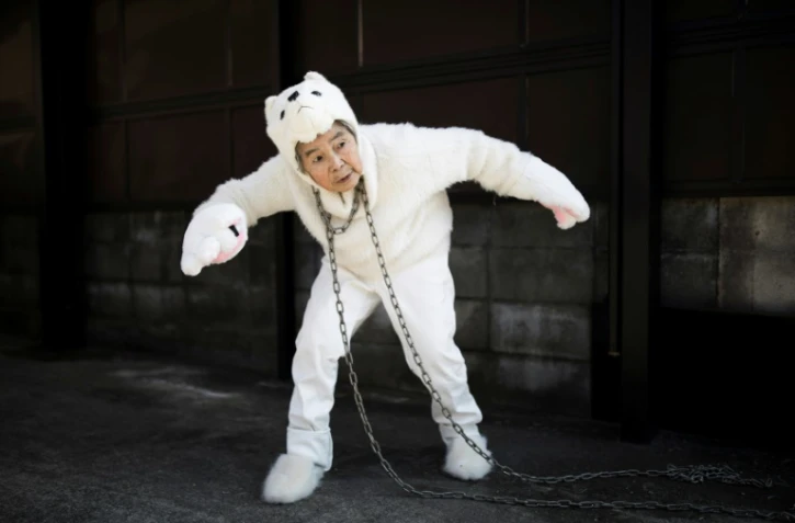 La Japonaise Kimiko Nishimoto vêtue d'un costume de chien pose pour un selfie devant sa maison, le 16 janvier 2018 à Kumamoto
