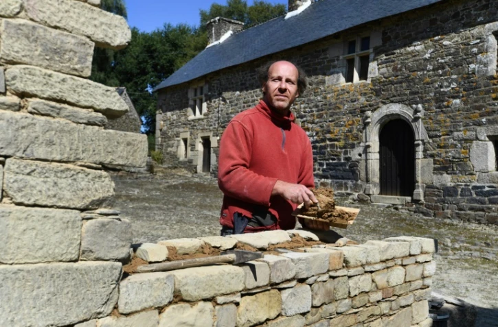 Olivier Thomas travaille à monter un muret dans son manoir, à Carnoët, le 22 août 2019