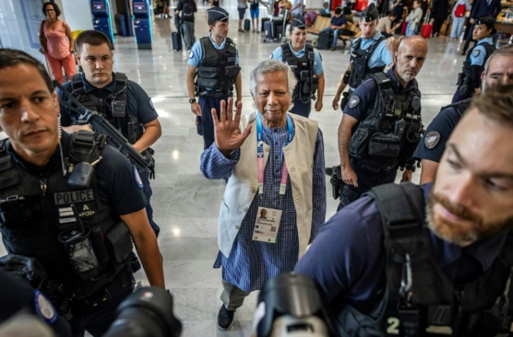 Le prix Nobel de la Paix Muhammad Yunus est escorté par la police française avant son départ pour le Bangladesh, le 7 août 2024 à l'aéroport de Paris-CDG.
