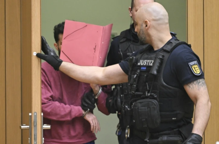 L'accusé (g) arrive dans la salle d'audience du tribunal régional de Stuttgart-Stammheim, dans le sud de l'Allemagne, le 13 février 2025