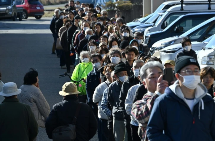 Après le séisme, des habitants font la queue pour recevoir de l'eau devant la mairie de Shika, dans le département d'Ishikawa, au Japon, le 2 janvier 2024