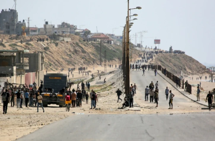 Des Palestiniens marchent le long d'une route près de Nuseirat, dans le centre de la bande de Gaza, le 21 mai 2024