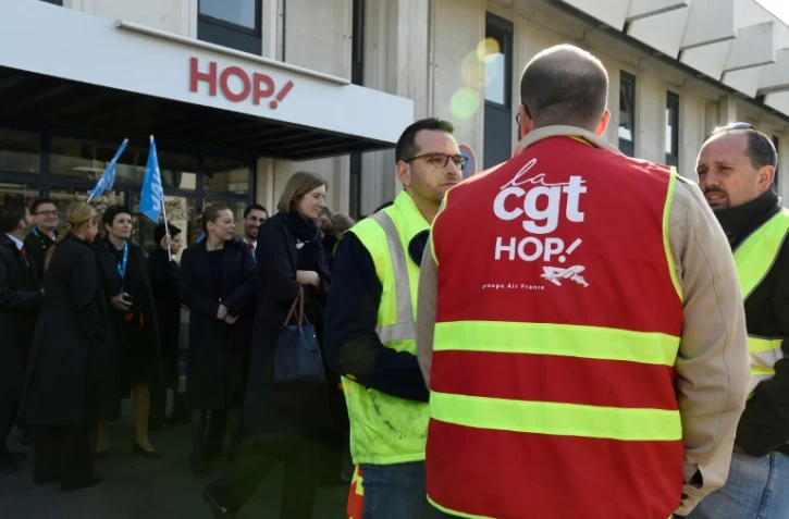 Un syndicaliste CGT et le personnel de la filiale d'Air France Hop! manifestent à l'extérieur du siège de la société à Rungis le 7 avril 2017