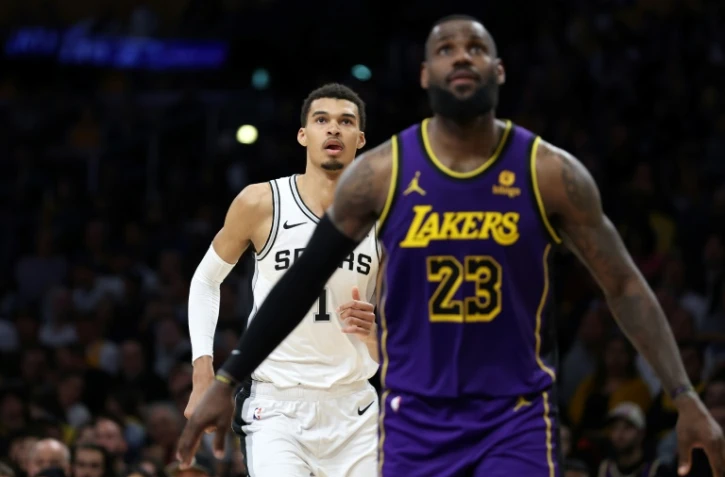 Le joueur français des San Antonio Spurs Victor Wembanyama (#1), avec devant lui la légende des LA Lakers LeBron James, lors d'un match de saison régulière de NBA, le 23 février 2024 à Los Angeles