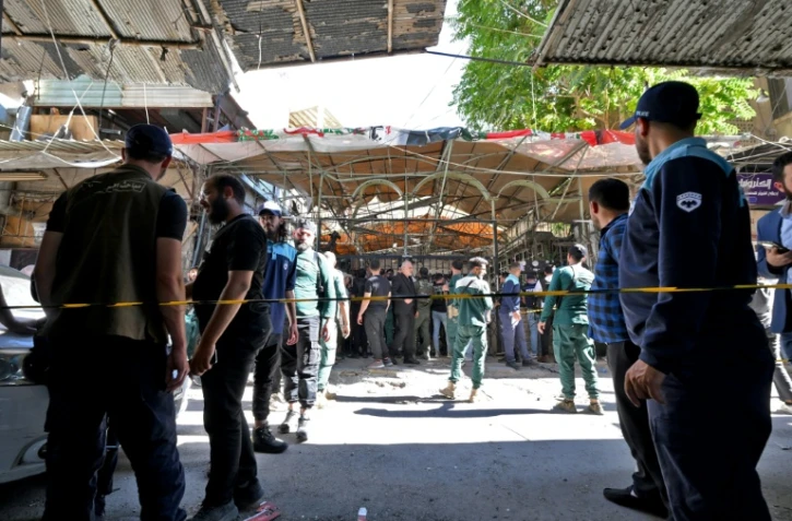 Les forces de sécurité syriennes et des passants sont rassemblés sur les lieux d'une explosion survenue dans un café de la capitale, Damas, le 2 juillet 2026