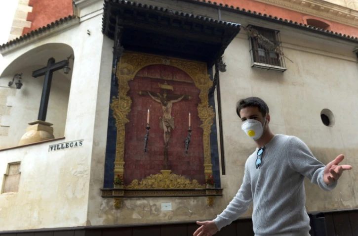 Un passant devant l'église Divino Salvador Collegiate à Séville, dans le sud de l'Espagne, le 14 mars 2020