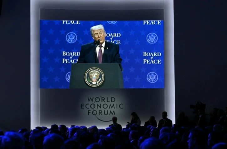 Le président américain Donald Trump apparaît sur un écran géant alors qu'il prend la parole lors de la réunion du "Conseil de la paix" pendant le Forum économique mondial (FEM) à Davos, le 22 janvier 2026 en Suisse