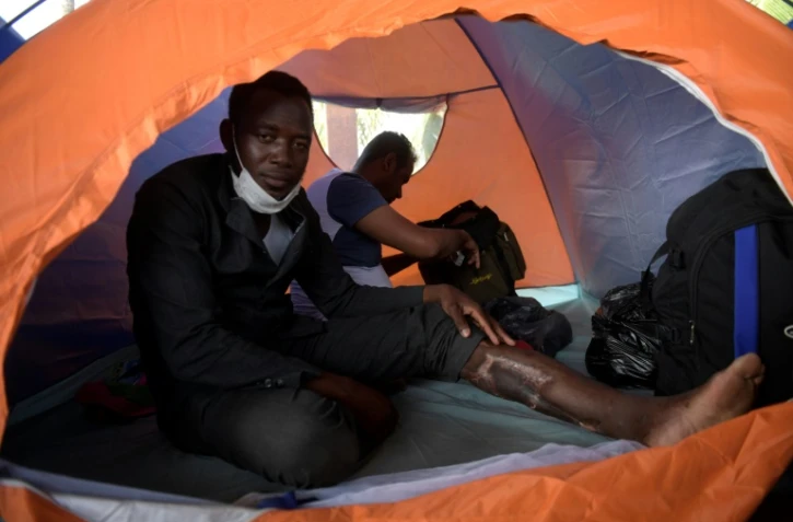 Un migrant africain Ahmed Kabeer à l'intérieur de sa tente parle avec l'AFP durant une interview dans un camp de fortune à Necocli, Colombie, on le 2 février 2021