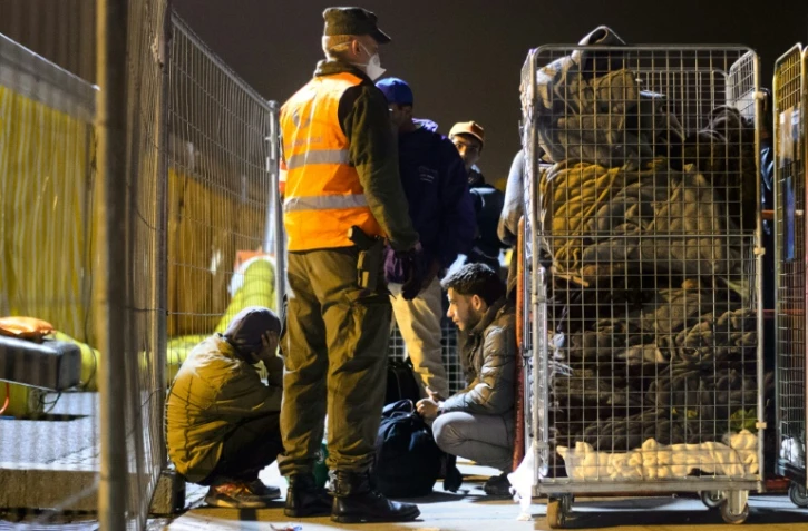 Des migrants attendent d'embarquer dans un bus à Sentilj (Slovénie), le 17 octobre 2015 pour les conduire en Autriche