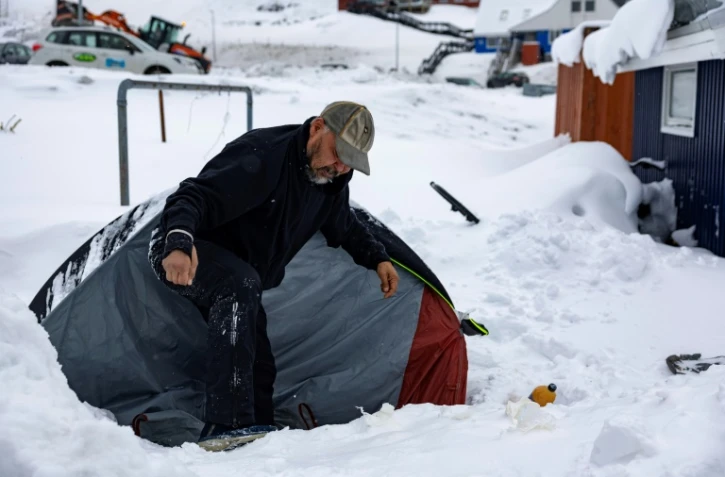 Anders Maqe à côté de sa tente entourée de neige à Nuuk, au Groenland, le 6 mars 2025