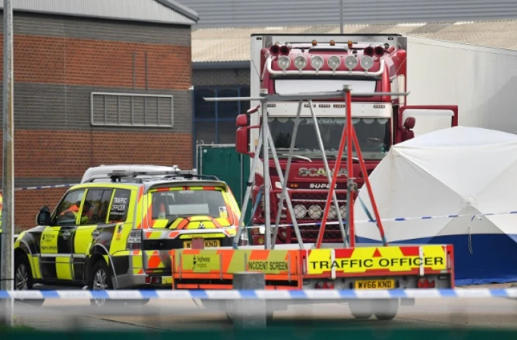 Des policiers britanniques montent la garde près du camion frigorifique dans lequel 39 morts ont été découverts à Grays, à l'est de Londres, le 23 octobre 2019