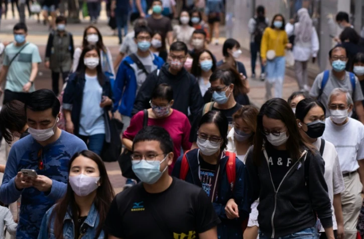Des passants portant des masques par précaution face au Covid-19, le 30 octobre 2021, dans une rue de Hong Kong 