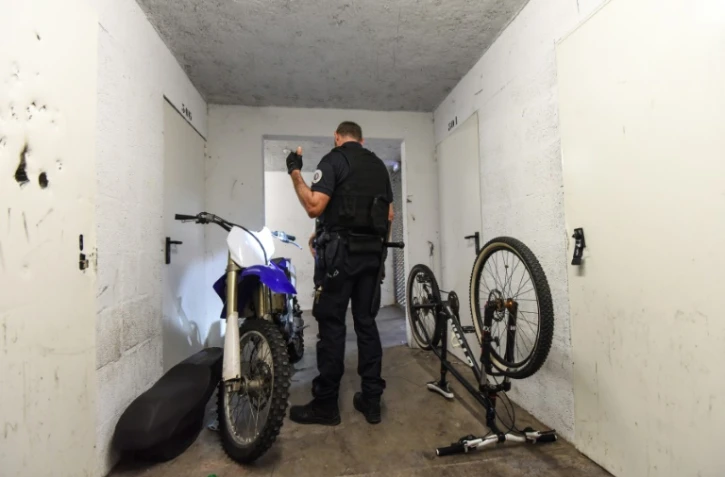 Un policier inspecte une moto dans la cave d'un immeuble dans le cadre d'une opération anti-rodéos urbains, le 11 août 2022 à Nantes