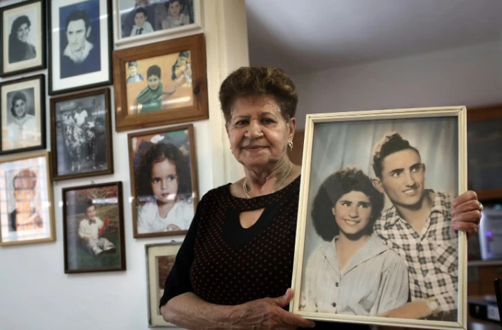 Yona Musa, 76 ans, d'origine yéménite, pose avec un portrait d'elle et son mari le 29 juin 2016 à Herzliya, près de Tel Aviv