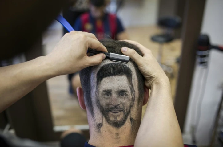 Le coiffeur serbe Mario Hvala dessine Messi sur l'arrière du crâne d'un client à Novi Sad, en Serbie, le 10 juin 2018 