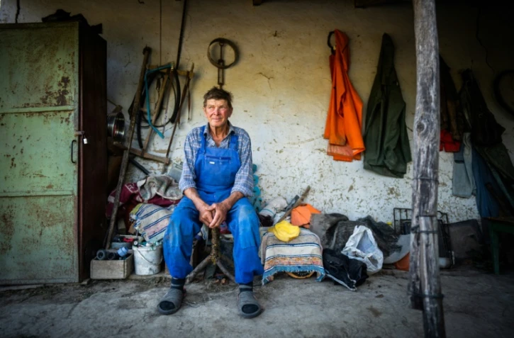 Ion Giuvanovici, 72 ans, assis devant sa maison à Plauru, à 300 km à l'est de Bucarest, le 11 septembre 2023