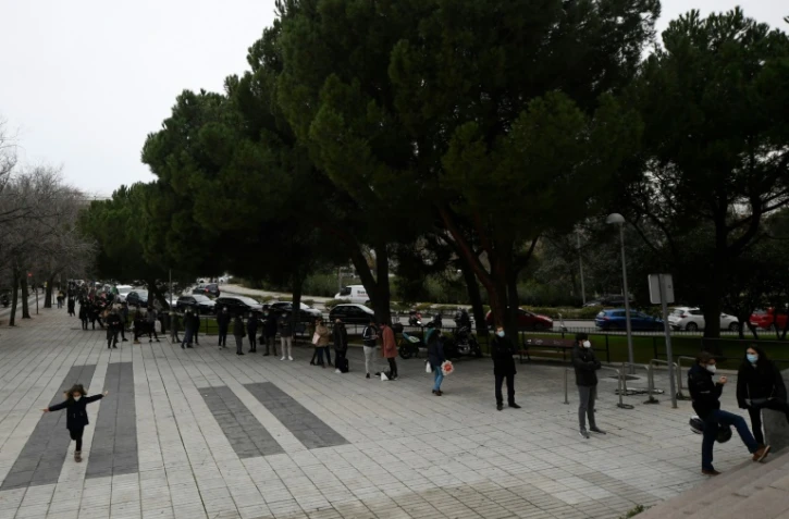 Des gens font la queue devant un laboratoire pour se faire tester au Covid-19, le 21 décembre 2020 à Madrid