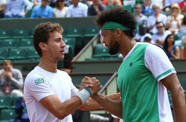 L'Argentin Renzo Olivo (g) serre la main de Jo-Wilfried Tsonga après sa victoire face au Français au 1er tour à Roland-Garros, le 31 mai 2017