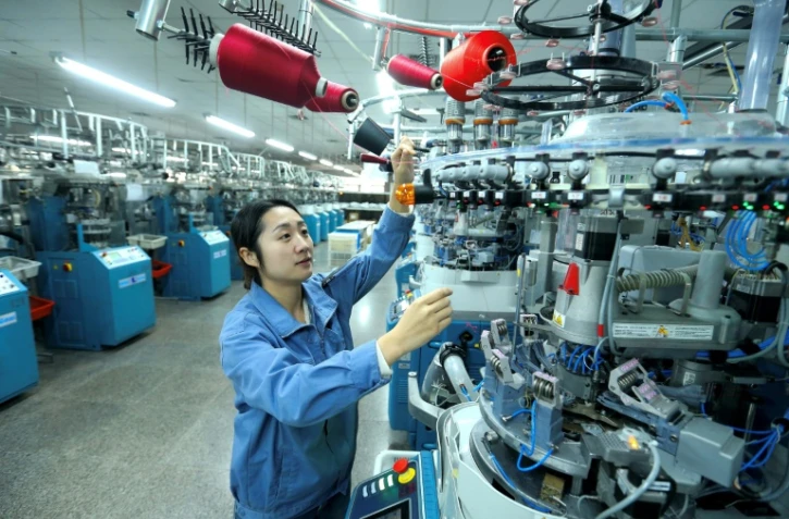 Un ouvrier utilise une machine dans une usine textile à Qingdao, dans la province du Shandong, dans l'est de la Chine, le 15 décembre 2025