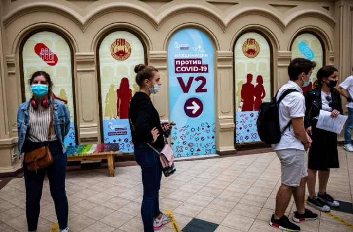 Des personnes font la queue devant un centre de vaccination contre le Covid-19 dans un centre commercial de Moscou le 29 juin 2021