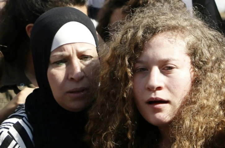 Le jeune Palestinienne Ahed Tamimi (D) avec sa mère à leur libération de prison après 8 mois de détention en Israël. Photo prise le 29 juillet 2018 près du village de Nabi Saleh en Cisjordanie occupée
