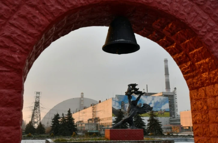 Un édifice devant le dôme géant recouvrant le réacteur de la centrale de Tchernobyl, le 8 décembre 2020