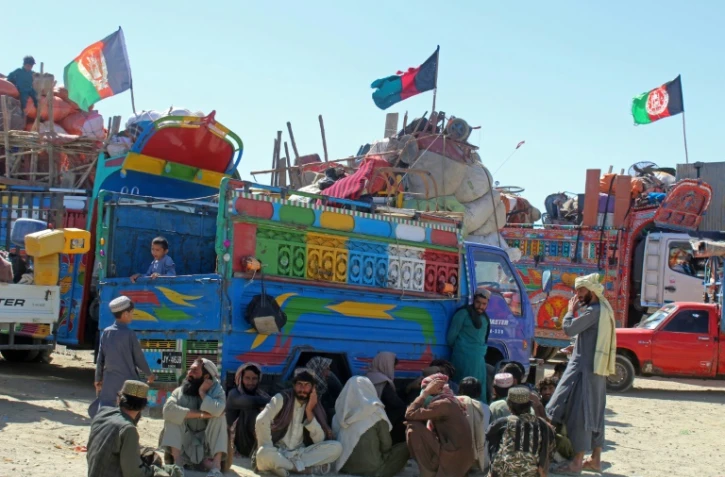 Des réfugiés afghans, expulsés du Pakistan, attendent à l'extérieur d'un centre de rétention à Chaman, près de la frontière pakistano-afghane, le 22 avril 2025