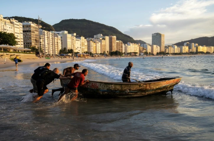 Des pêcheurs prennent l'eau depuis la plage de Copacabana, à Rio de Janeiro, au Brésil, le 23 mai 2023