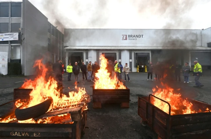 Des palettes brûlées devant l'usine Brandt où sont rassemblés des employés, le 11 décembre 2025 à Vendôme, dans le Loir-et-Cher