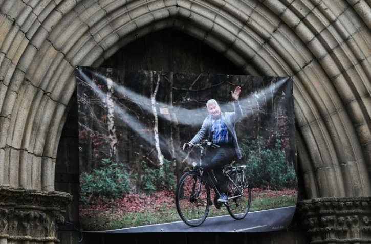 Le portail roman de la collégiale de Saint-Léonard-de-Noblat orné d'une grande photo de "Poupou" encore sur son vélo dans ses vieux jours, lors de ses funérailles, le 19 novembre 2019