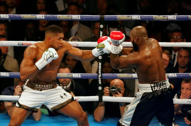 Le Britannique Anthony Joshua (g) face au Franco-Camerounais Carlos Takam pour défendre ses ceintures mondiales IBF et WBA des lourds, le 28 octobre 2018 à Cardiff
