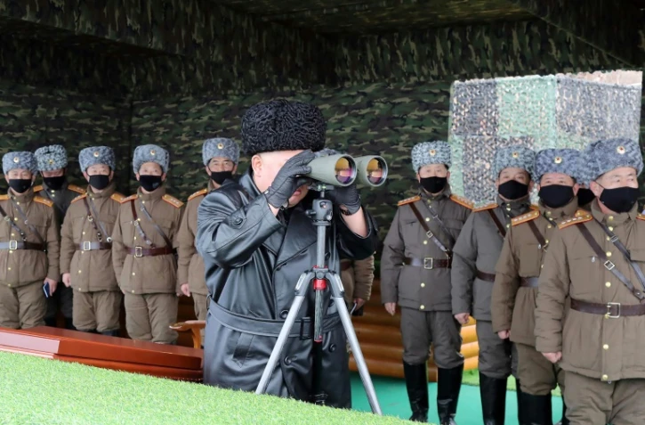 Le leader nord-coréen Kim Jong Un regarde à la jumelle un exercice militaire, le 28 février 2020 dans un lieu non précisé