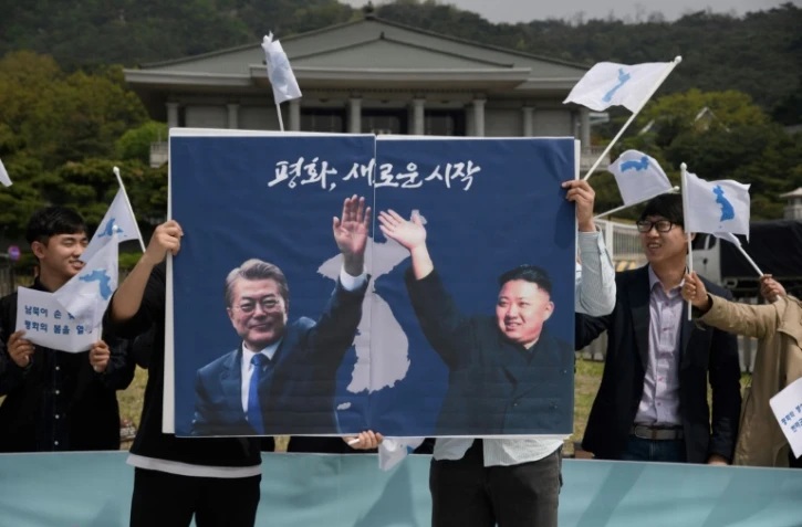 Les photos du président sud-coréen Moon Jae-in (g) et du leader nord-coréen Kim Jong-Un lors d'un rassemblement pour la paix, le 26 avril 2018 à Séoul