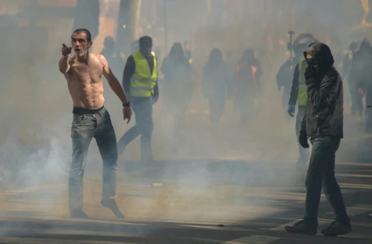 Un manifestant au milieu de gaz lacrymogènes lors d'une manifestation des Gilets Jaunes le 13 avril 2019 à Toulouse