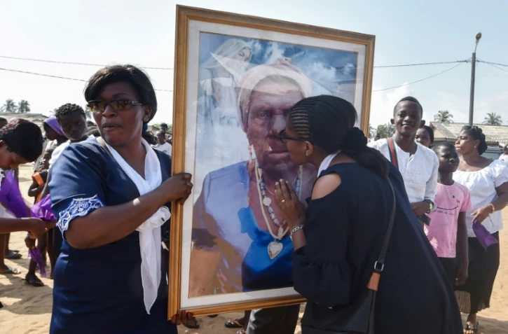 Les petites-filles de la centenaire décédée Anne M'Boua Ahoutié lui rendent hommage lors de son enterrement à Adjakoutié, un petit village à l'ouest d'Abidjan, le 3 août 2018