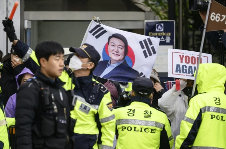 Des policiers attendent l'arrivée de l'ancien président sud-coréen Yoon Suk Yeol devant le tribunal deSéoul, le 14 avril 2025, face à des partisans de Yoon