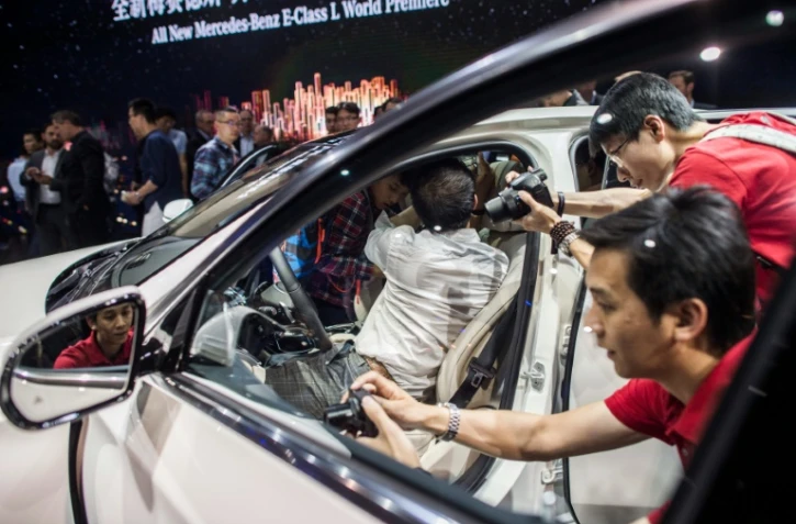 Des journalistes autour d'une Mercedes Benz E-Class le 24 avril 2015 au salon automobile de Pékin