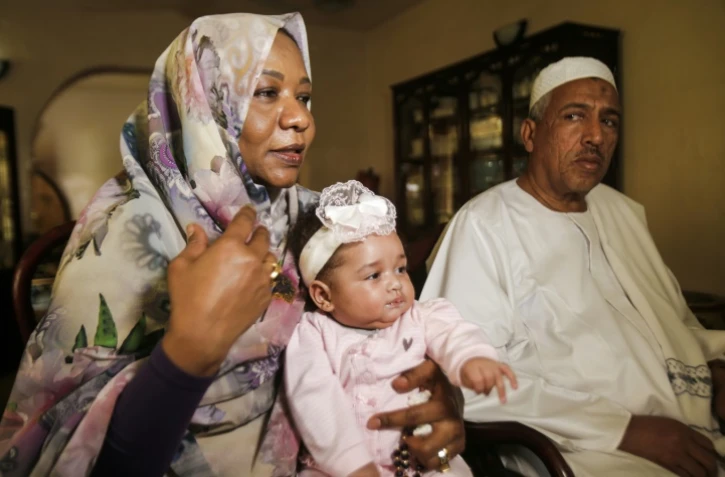 Alithi Youssef et son épouse Manal Fadlallah, les parents d'Aya, avec leur petite-fille Lojien, lors d'une interview avec l'AFP à leur domicile, le 4 mars 2017 dans la banlieue de Khartoum, au Soudan