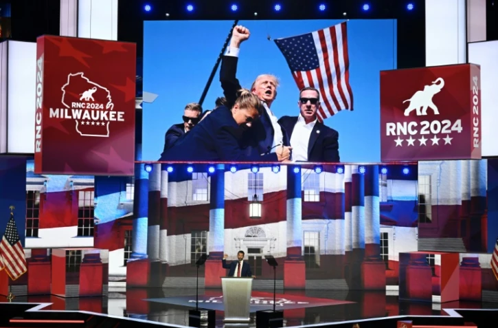 Donald Trump Junior, fils de Donald Trump, prononce un discours à la Convention républicaine de Milwaukee, avec une photo de son père survivant à une tentative d'assassinat en fond de décor
