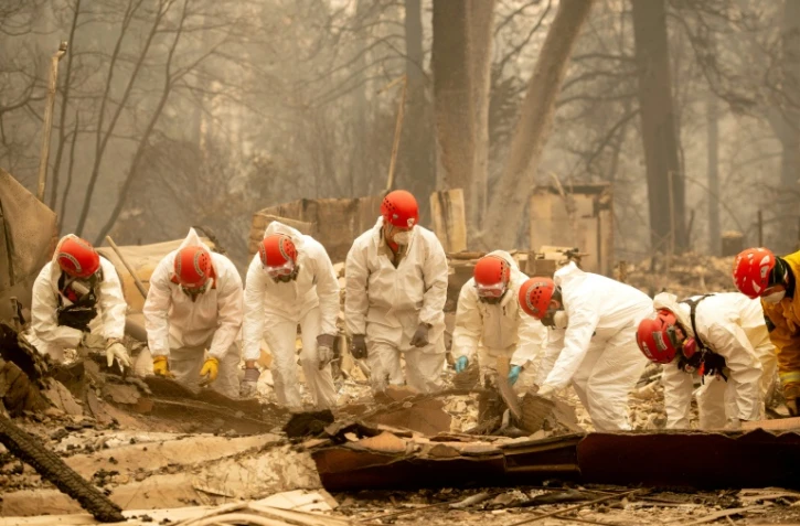 Les secours inspectent les décombres d'une maison à la recherche d'éventuelles victimes du gigantesque incendie qui ravage le nord de la Californie, le 14 novembre 2018 à Paradise
