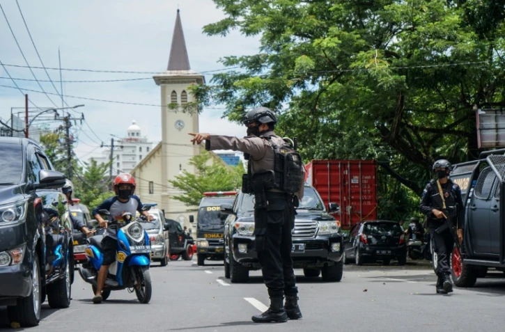 Un policier indonésien régule la circulation après un attentat suicide visant une église, à Makassar, en Indonésie, le 28 mars 2021