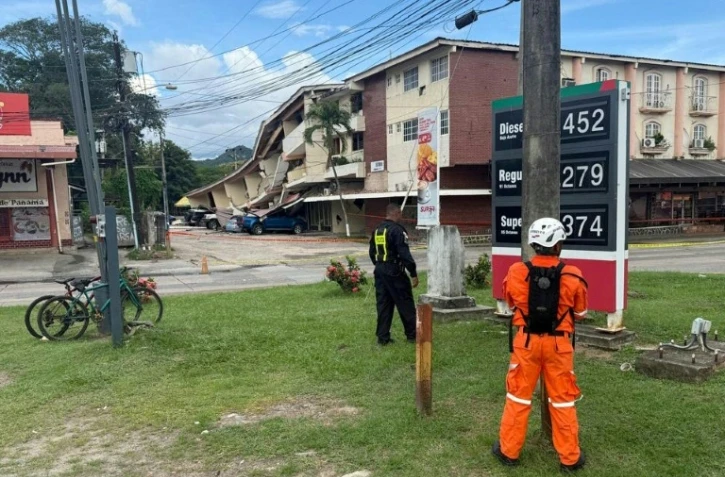 Un policier panaméen et un secouriste montent la garde à côté d'un immeuble effondré après un séisme, à Penonomé, au Panama, le 9 octobre 2026