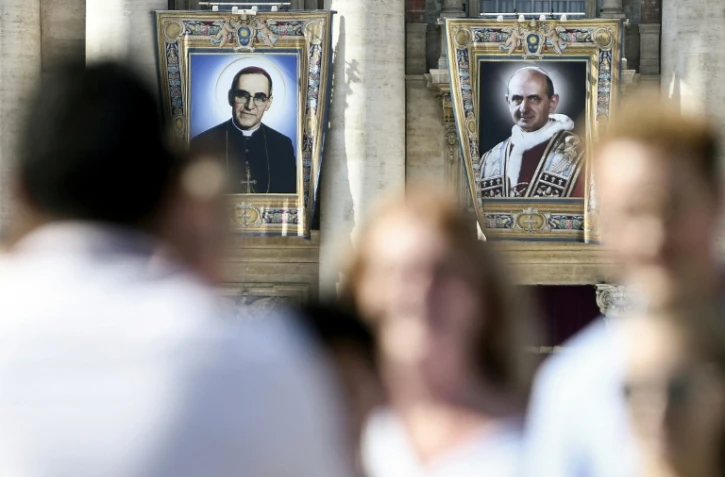 Portraits de l'archevêque salvadorien Oscar Romero (g) et du pape Paul VI (d) sur la façade de la Basilique Saint-Pierre, au Vatican, le 13 octobre 2018