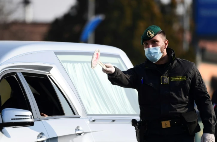 Un carabinier vérifie l'identité d'une conductrice à l'entrée de la ville de Zorlesco au sud-est de Milan, le 24 février 2020